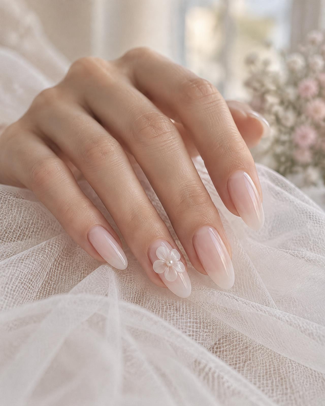 Mano con unghie a mandorla rosa lattiginoso, fiore 3D bianco e perla su tulle, Umi Nail Rosà